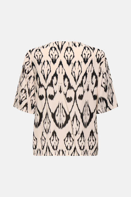Blouse beige à manches courtes de JDY, avec un motif ikat noir et un tissu texturé.
