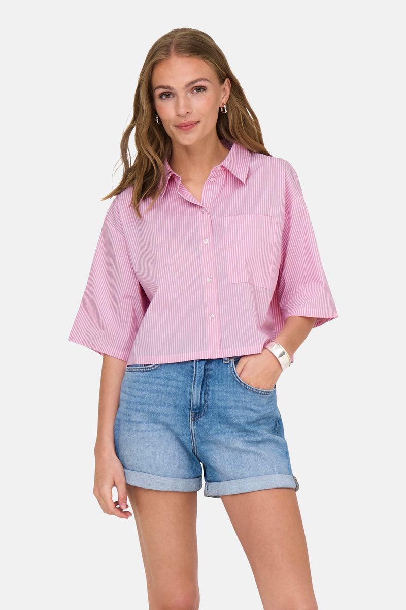Chemisier rose rayé de JDY, porté avec un short en jean retroussé et un bracelet argenté.
