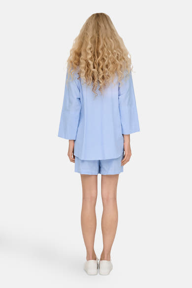 Blauwe blouse met lange mouwen van ONLY, verticaal gestreept, gedragen met een bijpassende korte broek, achtergezicht.