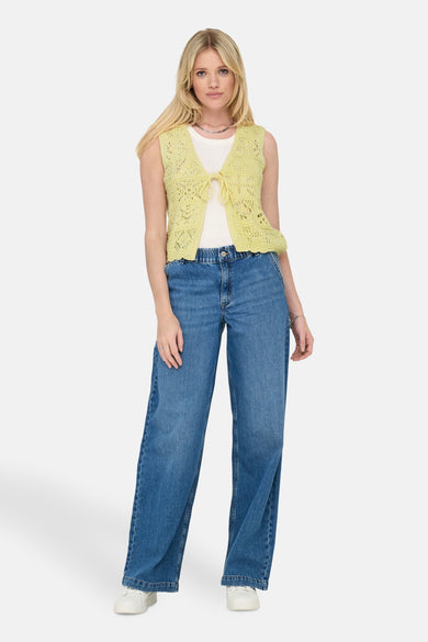 Geel vest met open breisel van ONLY, gedragen over een wit T-shirt en een wijde jeans.