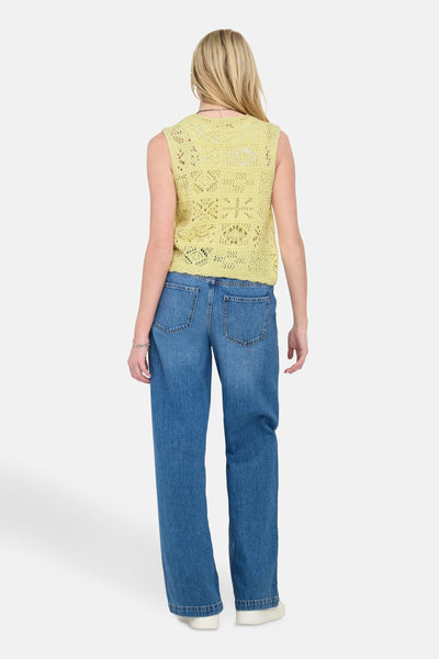 Gele Only® gehaakte vest, gedragen met een high-waisted jeans en witte schoenen.Achteruitzicht.