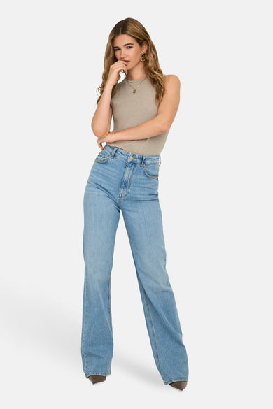 Débardeur beige ONLY® porté avec un jean taille haute et des boucles d'oreilles dorées.