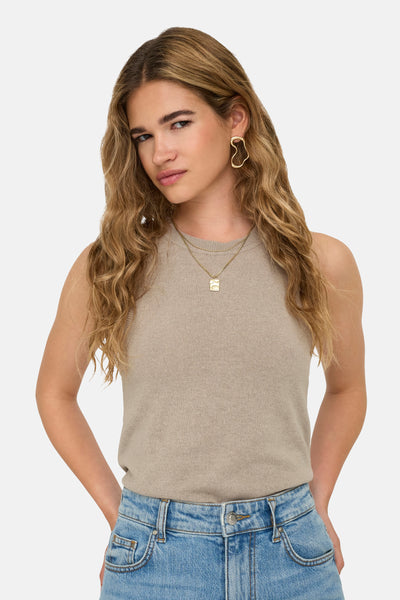 Top beige sans manches de ONLY, porté avec un jean taille haute et des bijoux dorés
