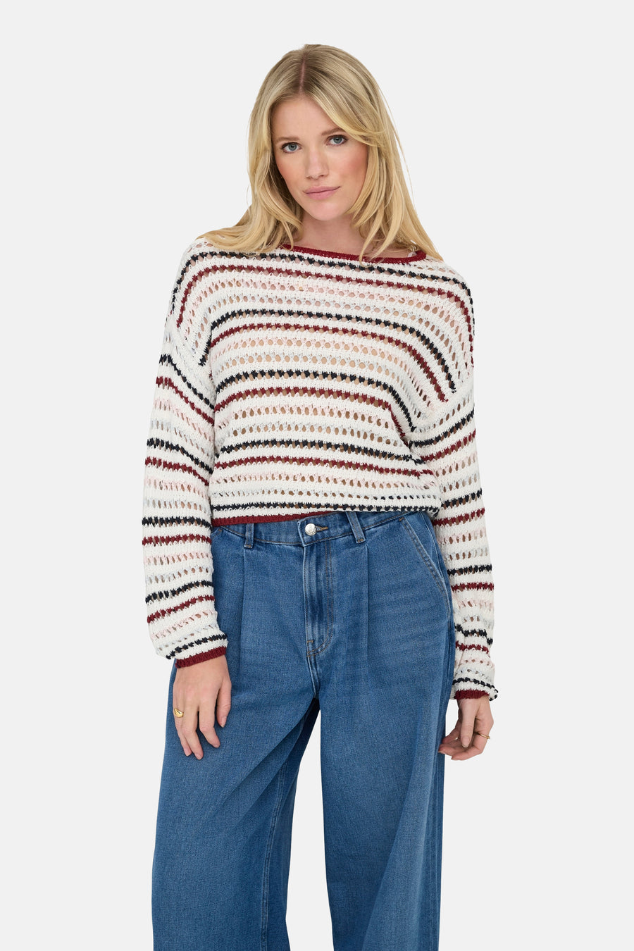 Pull à col rond multicolore de ONLY, à rayures horizontales et larges mailles, porté avec un jean bleu taille haute.
