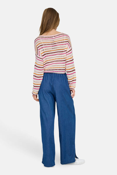 Pull à col rond multicolore de ONLY, avec motif rayé et texture ajourée, porté avec un pantalon bleu large.