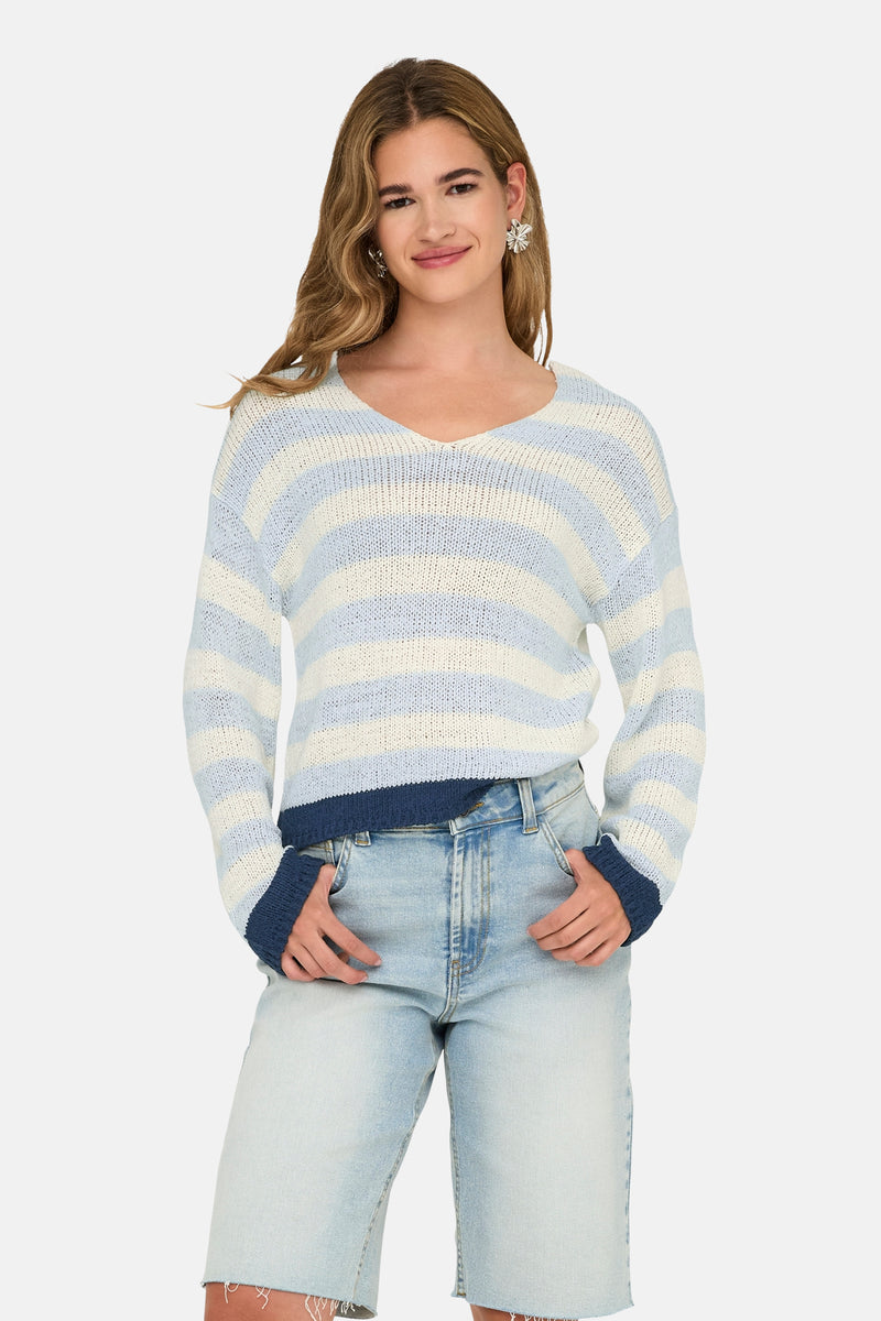 Pull à col en V bleu rayé by ONLY, porté avec un short en jean et des boucles d'oreilles argentées.