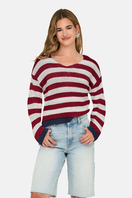 Multikleuren V-hals trui van ONLY, met horizontale strepen, gedragen met een verbleekte spijkerbroekshort en zilveren oorbellen.