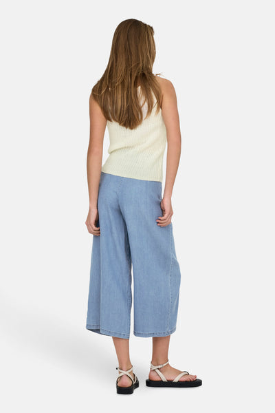 Beige tanktop van ONLY®, gedragen met een wijde blauwe broek en zwarte plateauzolen.