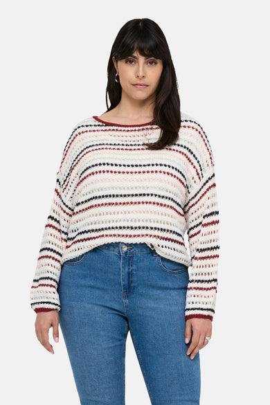 Pull à col rond multicolore de CARMAKOMA, à rayures horizontales ajourées porté avec un jean bleu classique.
