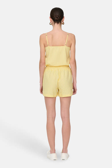 Gele gestreepte short van JDY, gedragen met een bijpassend topje en witte schoenen.