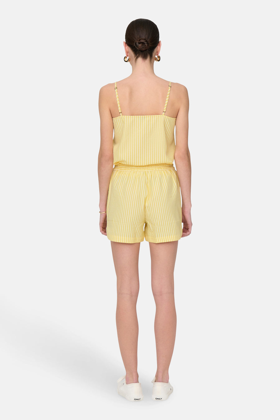 Gele gestreepte short van JDY, gedragen met een bijpassend topje en witte schoenen.