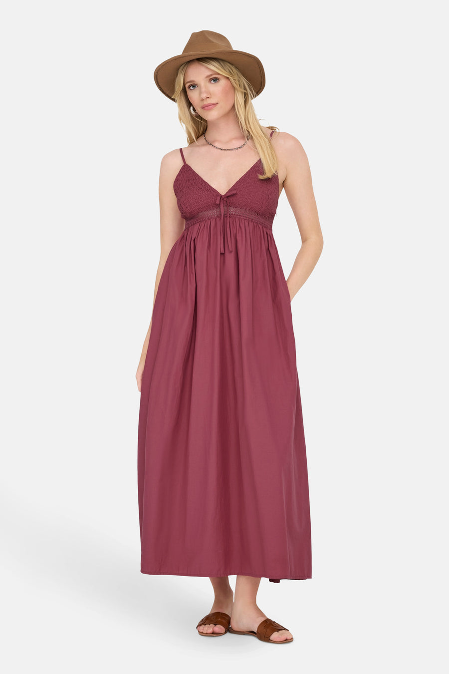 Robe longue rouge de ONLY, avec un haut smocké, et accessoirisée d'un chapeau en feutre marron et de sandales en cuir tressé.