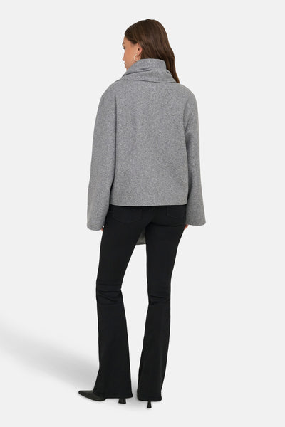 Veste courte grise de ONLY, avec un col châle ample, portée avec un jean noir évasé.
