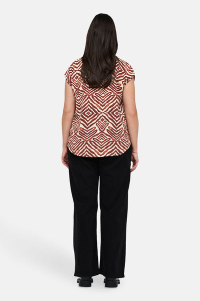Chemisier sans manches multicolore de CARMAKOMA, imprimé losanges, porté avec un pantalon noir ample.