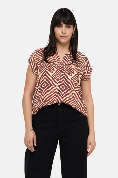 Chemisier sans manches multicolore de CARMAKOMA, imprimé zèbre marron et beige, porté avec un pantalon noir.
