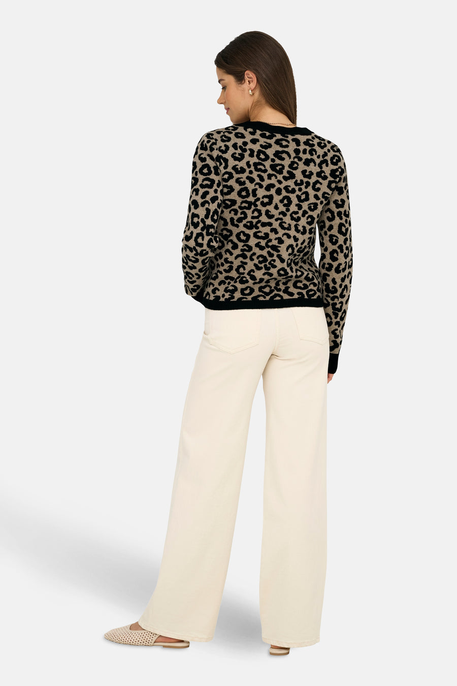 Cardigan multicolore de ONLY, motif léopard noir et beige, porté avec un pantalon écru et des chaussures plates.