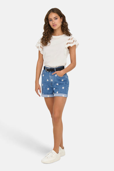 T-shirt blanc à manches courtes de ONLY, orné de bordures ajourées, porté avec un short en jean à motifs fleuris.