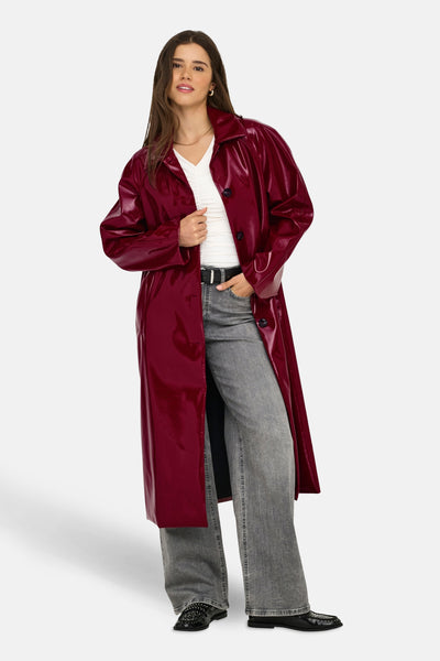 Lange bordeaux vinyljas van ONLY®, gedragen over een wit T-shirt en een grijze jeans.