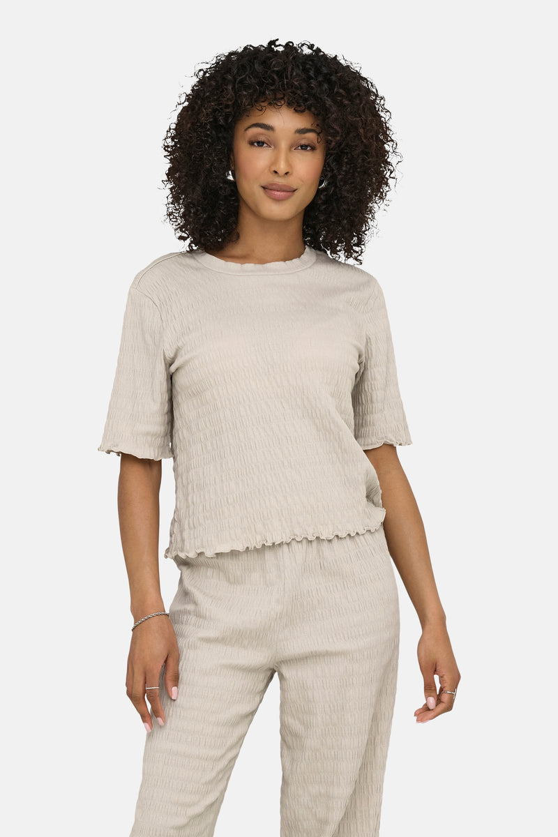 Beige T-shirt met korte mouwen van ONLY, van getextureerde stof gedragen met een armband en ringen.