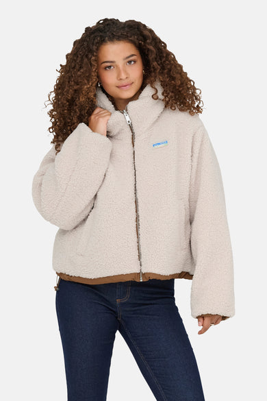 Veste courte écru de ONLY, en imitation peau de mouton, portée avec un jean bleu foncé
