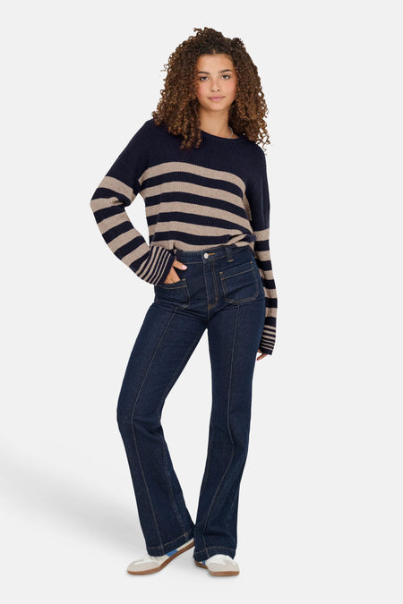 Ronde hals trui van ONLY in blauwe gebreide stof met beige strepen, gedragen met een high-waisted jeans en sneakers.