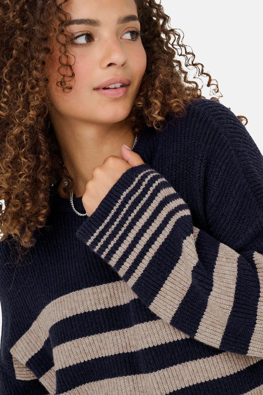 Pull bleu à col rond de ONLY, à rayures horizontales beiges, porté avec un collier argenté.