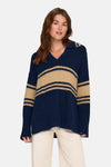 Pull bleu à rayures contrastantes de ONLY, porté avec un pantalon clair et un collier doré.
