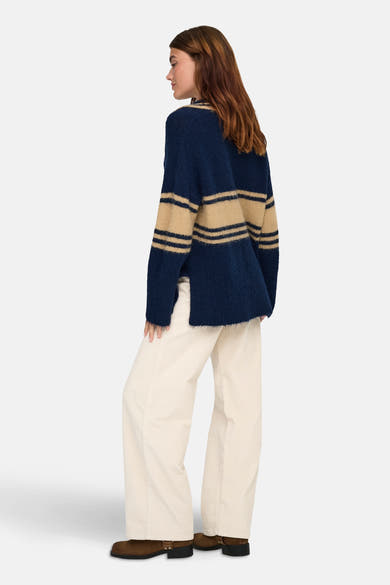 Pull bleu rayé de ONLY, porté avec un pantalon en velours côtelé et des bottines marron, vue de dos.

