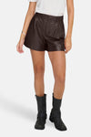 Short brun ONLY® porté avec un t-shirt blanc et des bottes noires