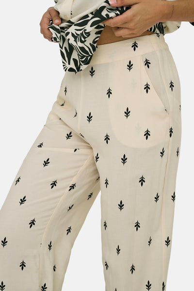 Pantalon écru de JDY avec motif de feuilles noires, poche latérale et coupe ample.