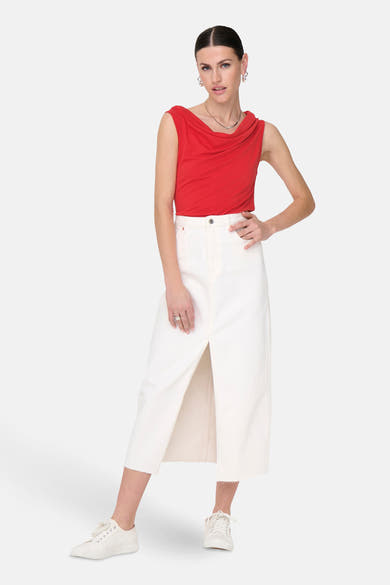 Top rouge sans manches de JDY, porté avec une jupe blanche fendue et des chaussures de sport blanches.
