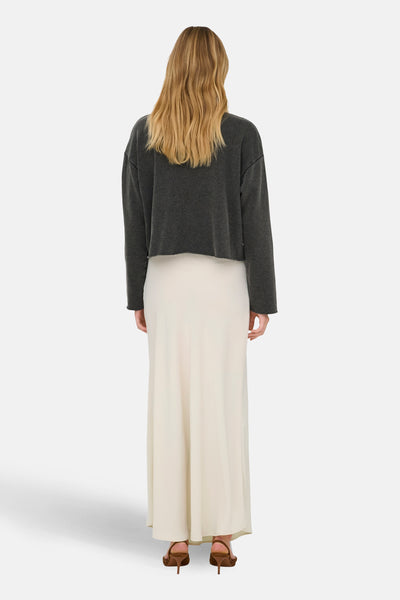 Zwarte ONLY® trui met lange mouwen, gedragen met een lange crèmekleurige rok en bruine hakken.