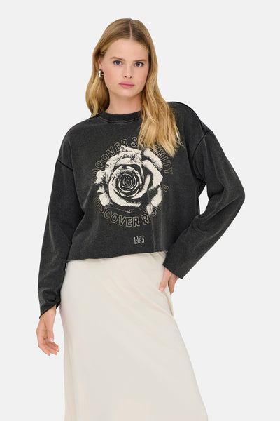 Sweat noir à col rond par ONLY orné d'un imprimé rose et porté avec une jupe longue crème.