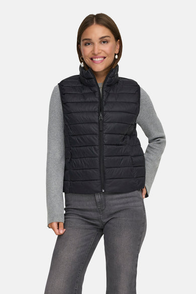 Veste sans manches noire de ONLY®, portée avec un pull gris et un jean gris.