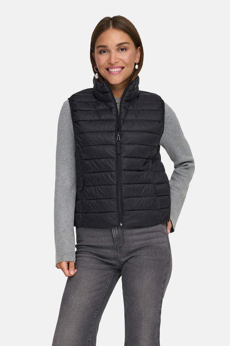 Veste sans manches noire de ONLY®, portée avec un pull gris et un jean gris.