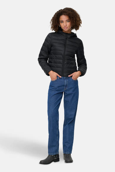 Zwarte regenjas van ONLY, gedragen met een blauwe jeans en zwarte enkellaarsjes.