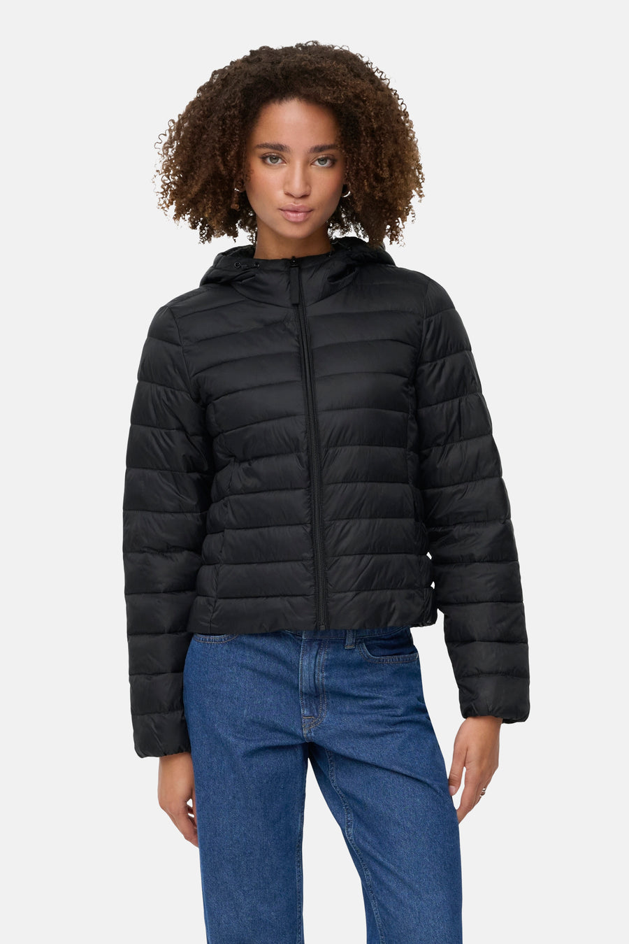 Zwarte regenjas van ONLY, met capuchon en ritssluiting op een model met een blauwe spijkerbroek.