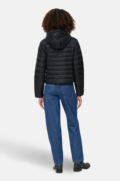 Zwarte regenjas van ONLY, met capuchon, gedragen met een wijde blauwe jeans en zwarte laarzen.