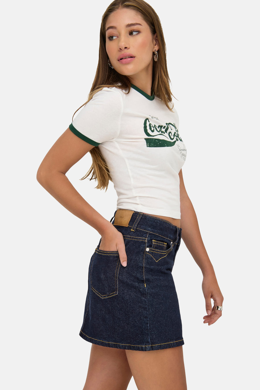 Korte donkerblauwe spijkerrok van ONLY®, met contrasterende stiksels en zichtbaar logopatch, gedragen met een T-shirt met print.