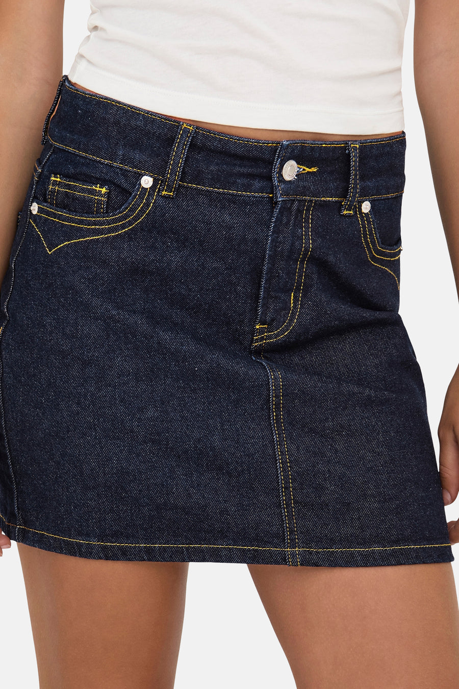 Donkerblauwe denim minirok van ONLY, met gele contrasterende stiksels en zichtbare zakdetails.