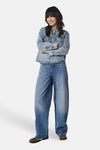 Dark blue wide-leg denim jeans by ONLY®, featuring a relaxed fit, subtle fading, and straight hem, shown with a denim shirt and brown boots in full-length lifestyle view.