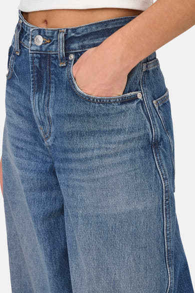 Dark blue denim jeans by ONLY® with faded wash, front pocket detail, and silver button closure, shown in close-up side view.