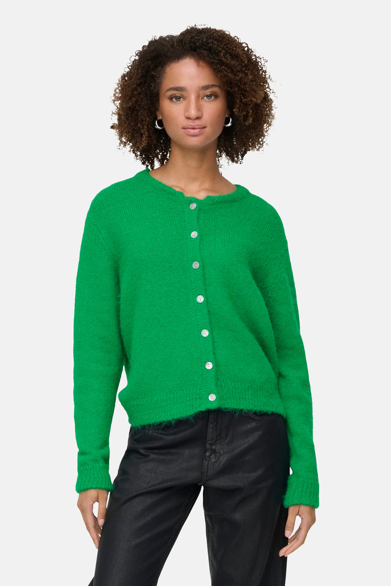 Groene cardigan van ONLY, gedragen met een zwarte broek en enkellaarsjes met hak.