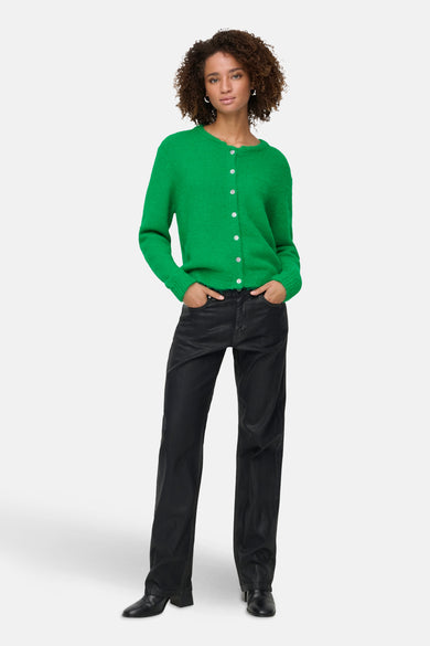 Cardigan vert de ONLY, porté avec un pantalon noir et des bottes à talons.