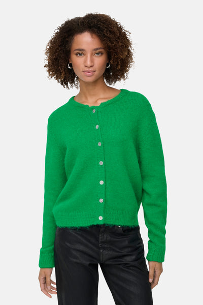 Groene, pluizige gebreide cardigan van ONLY, gedragen door een model met een zwarte broek.