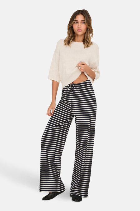 Beige ronde hals trui van ONLY®, gedragen met een zwart-wit gestreepte broek.