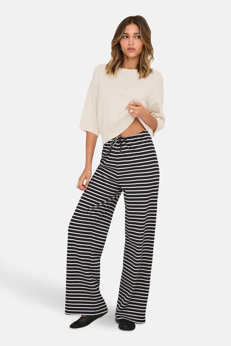 Beige ronde hals trui van ONLY®, gedragen met een zwart-wit gestreepte broek.