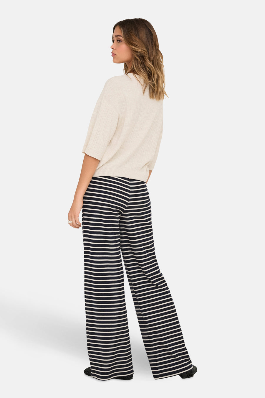 Beige trui met ronde hals van ONLY, gedragen met een zwart-wit gestreepte broek
