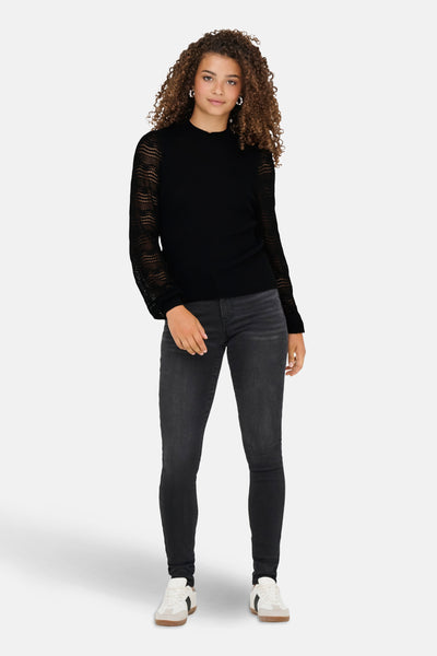 Zwarte trui van ONLY, met kanten lange mouwen en gedragen met een zwarte jeans en witte sneakers.