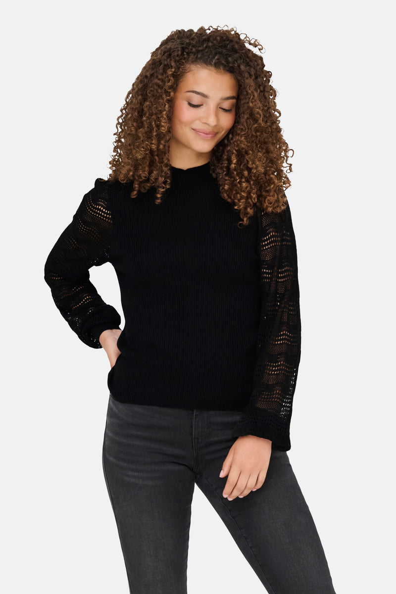 Zwarte gebreide trui van ONLY®, met kanten lange mouwen en een zwarte broek.